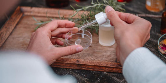 Junge Frau, die mit einer Pipette ein Hyaluron-Serum von Botanik atelier auf eine Petrischale tropft. 